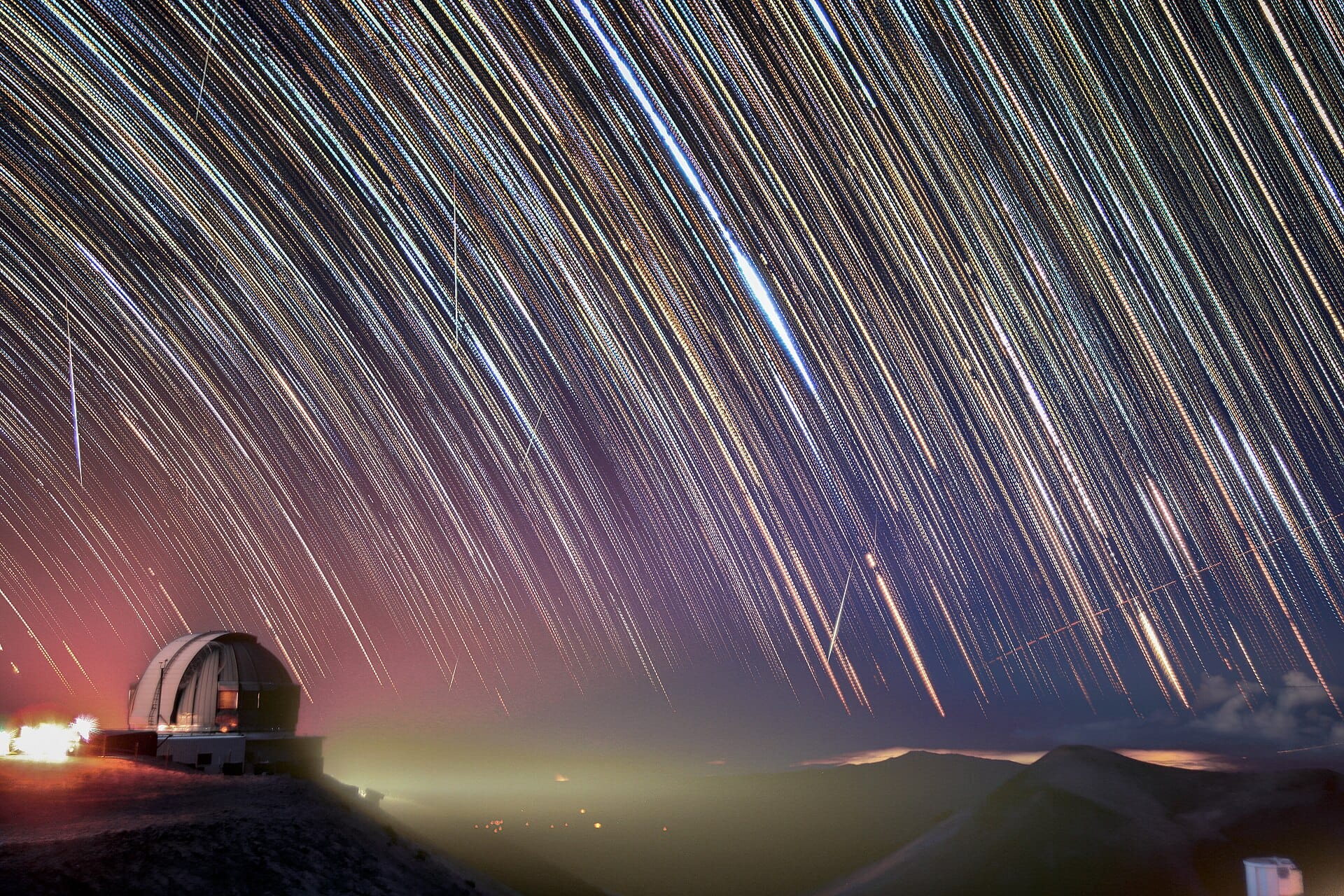 Several Geminid meteor trails over the Gemini North observatory dome at night